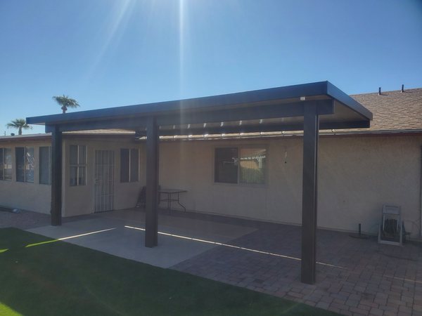 Attached dark solid aluminum patio cover over turf for Centennial Hills area homeowners.