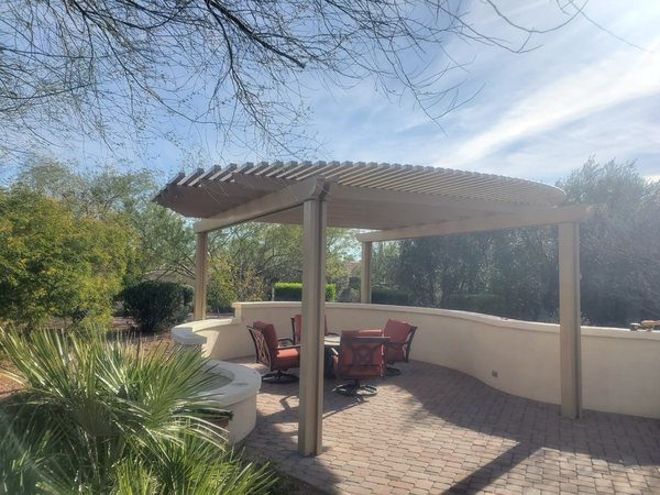 Tan lattice patio cover with desert landscaping for Mesquite area homes.