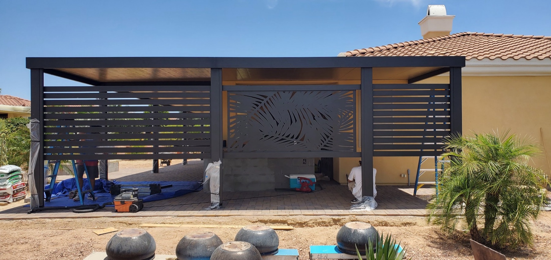 Modern dark aluminum patio cover with privacy slats for Henderson area homeowners.