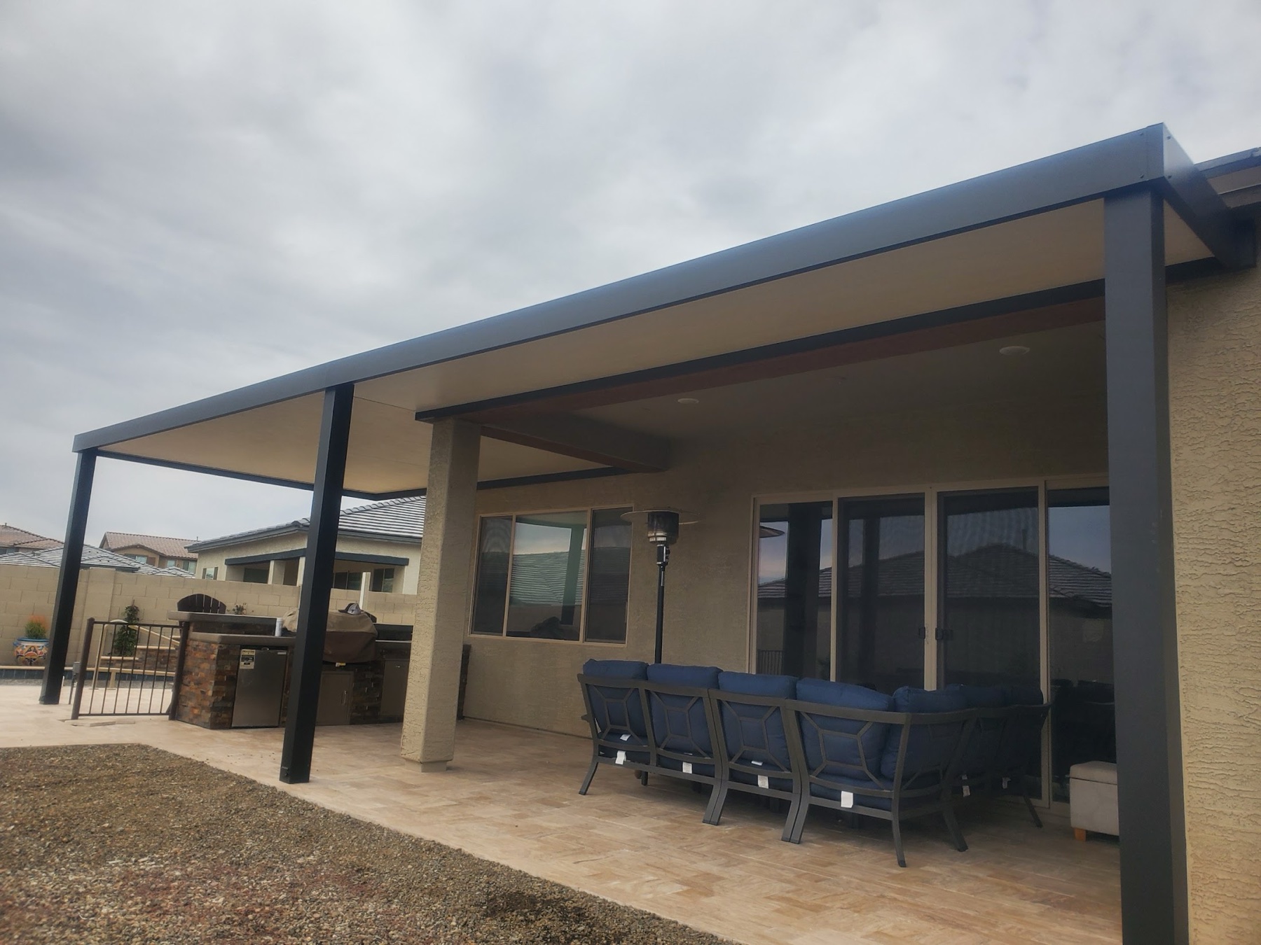 Long attached dark patio cover with seating for Las Vegas area homeowners.