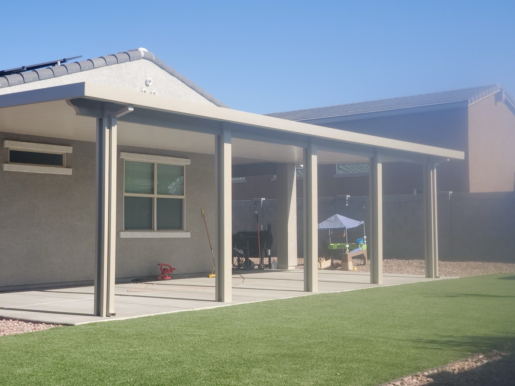 Attached patio cover over turf for Henderson area homeowners.