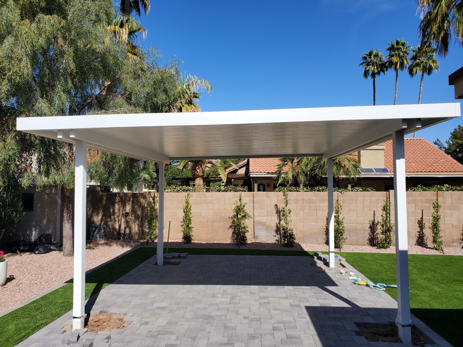 White freestanding patio cover with palms for Boulder City area homes.